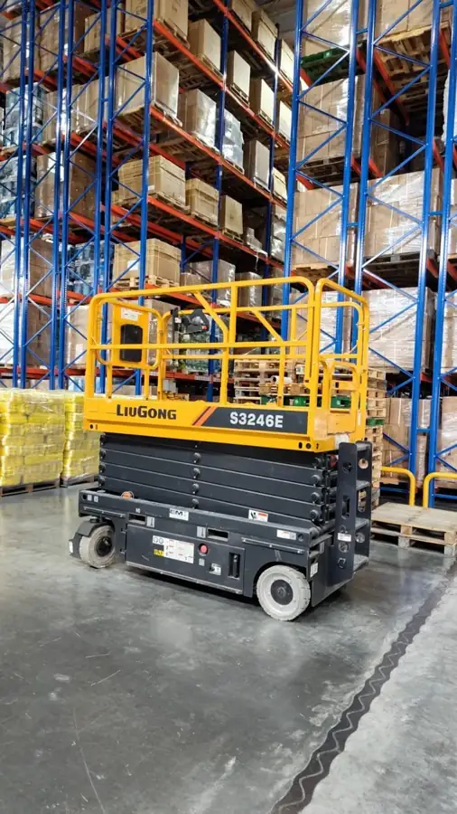 Plataforma de tijera LiuGong S3246E frente a racks altos